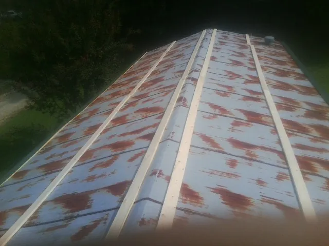 Rusted metal roof panels with new wood purlins before replacement — Storm Damage Roof Repair in Conover by Roofing Brothers