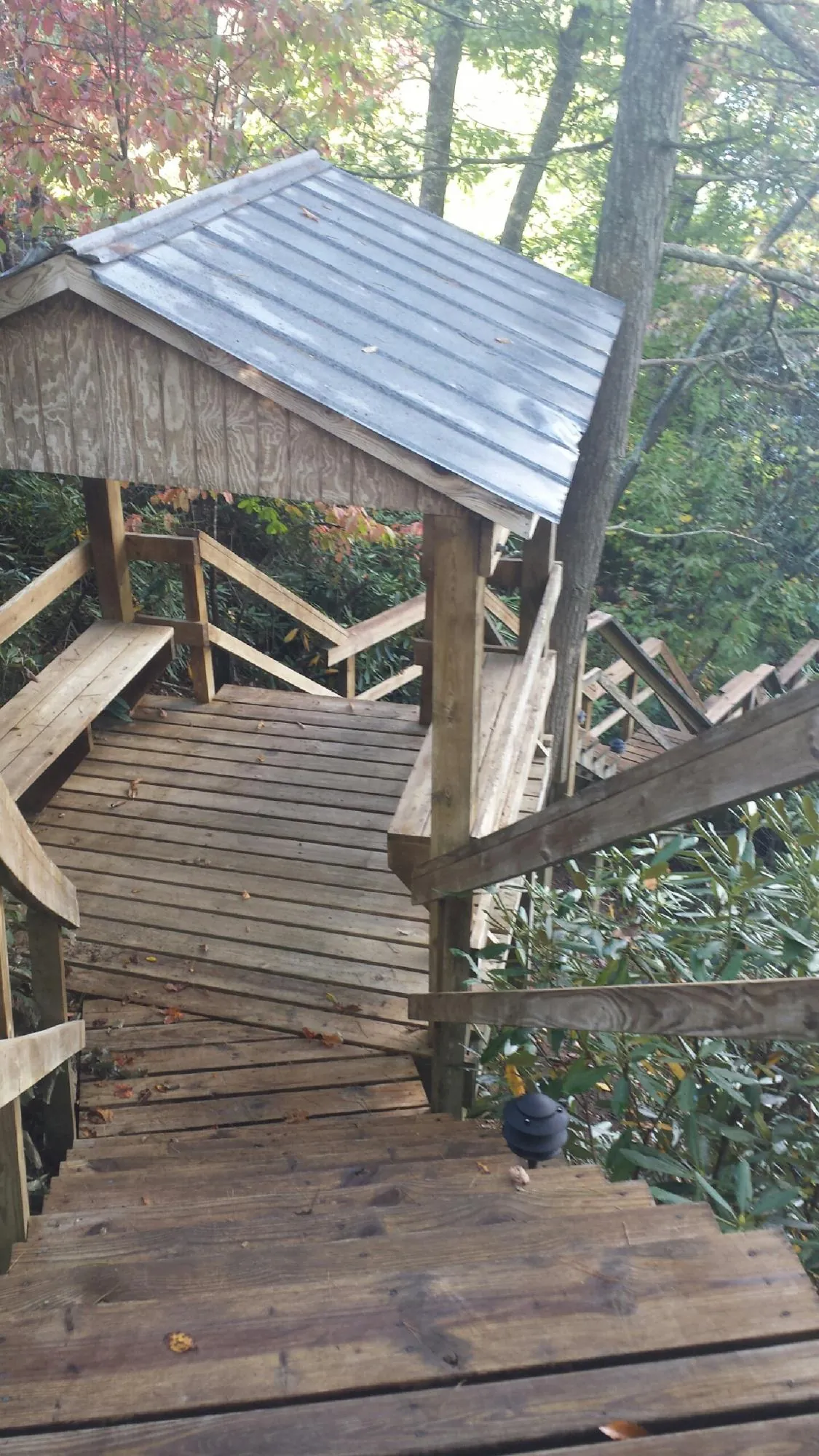 Metal roofed shelter over wooden steps on a wooded walkway — Skylight Repair & Installation work by our crew in Conover