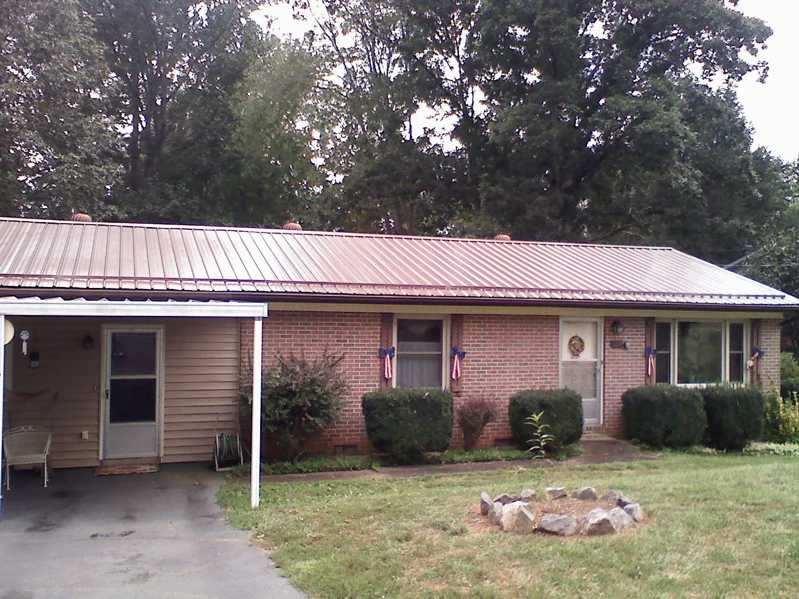 Bronze metal roof and carport on a brick ranch home — Roof Repair work by our crew in Conover
