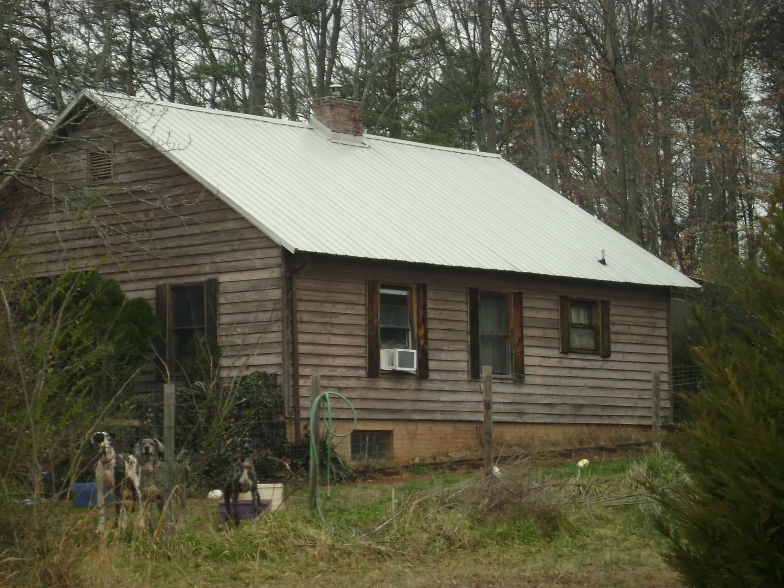 White metal roof on an old wood sided farmhouse, from a Metal Roof Installation job in Conover